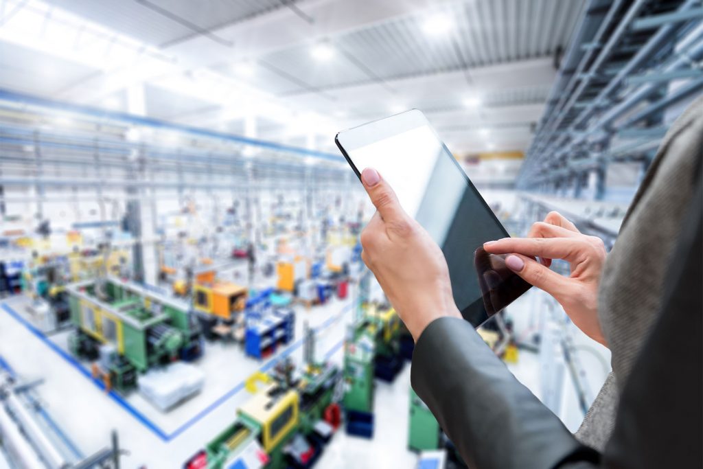 Manager using a tablet in a factory